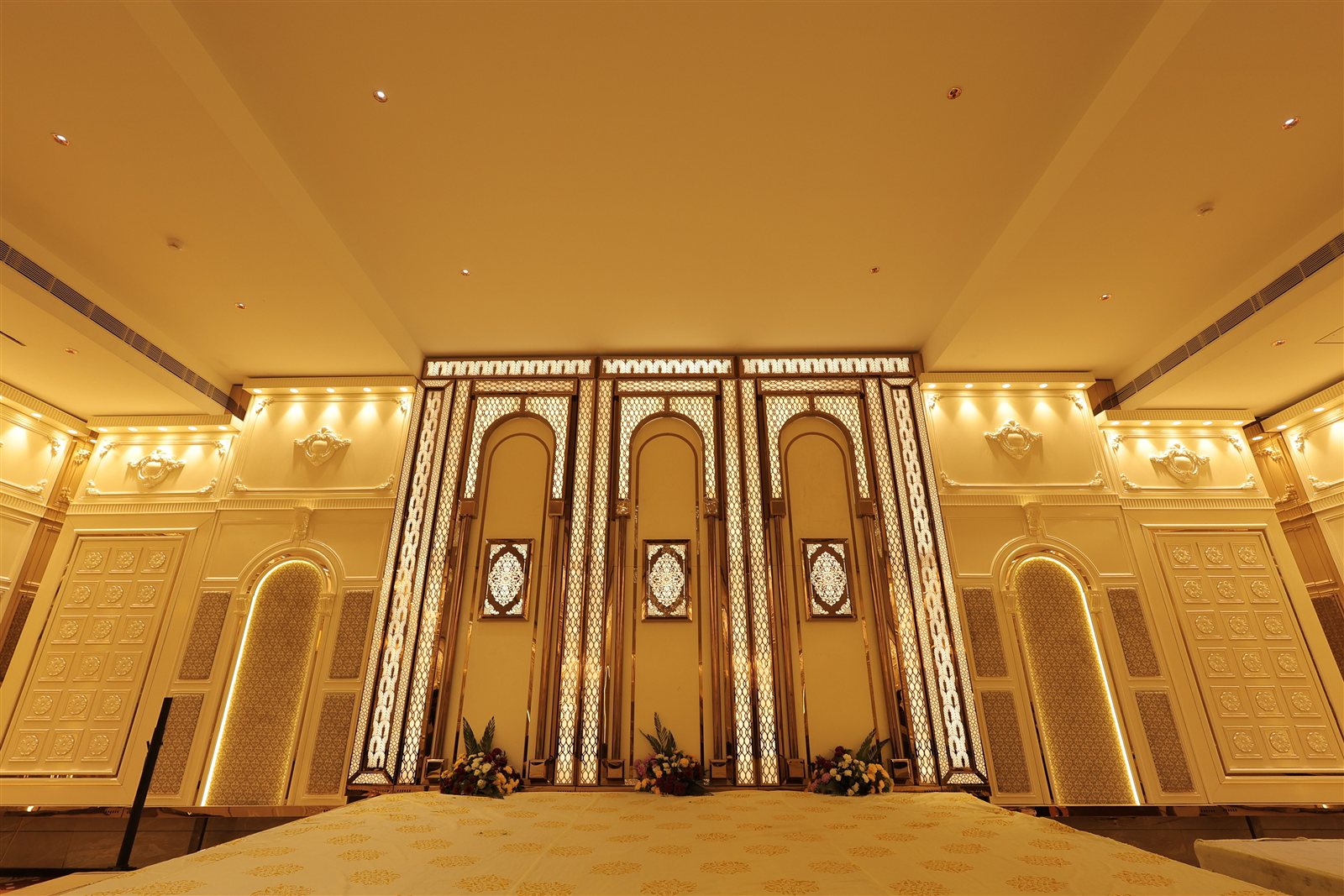 Ornate golden stage and archway inside Jajarmaan's grand function hall